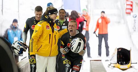 Francesco Friedrich (M) feiert seinen Sieg im Zweierbob enthusiastisch. Foto: Jan Hetfleisch