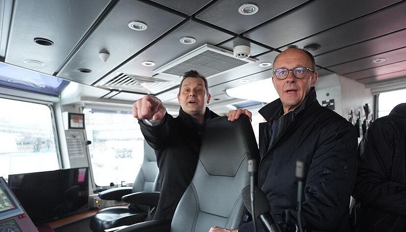 Unionskanzlerkandidat Friedrich Merz l&auml;sst sich vom Inhaber des Hamburger Unternehmens VB Group beim Besuch des Feuerl&ouml;schboots &laquo;Prag&raquo; den Hamburger Hafen zeigen.