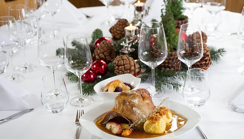 Die Tafel ist weihnachtlich gedeckt. Klassischerweise passen zur Weihnachtsgans-Portion Klöße.