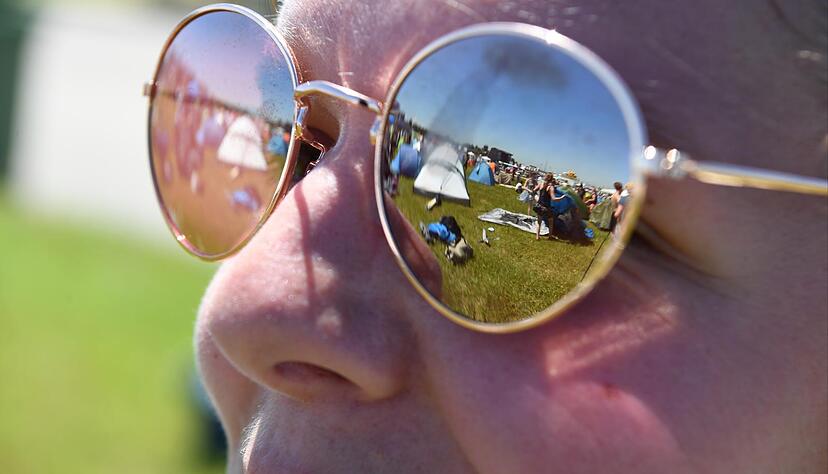 In der Brille einer Festivalbesucherin spiegelt sich einen Tag vor Beginn des Southside-Festivals in Neuhausen das Festivalgelände wider. In der Brille einer Festivalbesucherin spiegelt sich einen Tag vor Beginn des Southside-Festivals in Neuhausen das Festivalgelände wider.