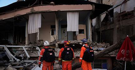 Mitglieder eines britischen Rettungsteams suchen im türkischen Antakya nach Überlebenden.