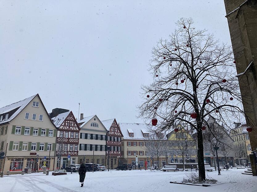 Die roten großen Kugeln hängen noch im Baum bei der Stiftskirche. Passend dazu ist der Öhringer Marktplatz nun winterlich weiß.