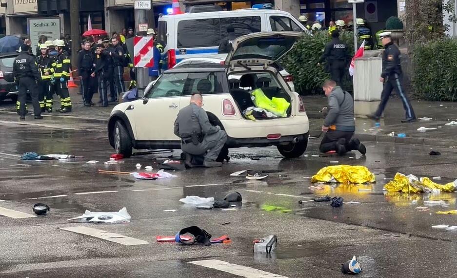 Polizisten untersuchen ein Auto in der Nähe des Einsatzortes in der Münchner Innenstadt.