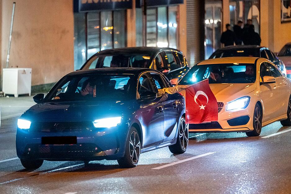 Fans schwenkten Fahnen aus den Fahrzeugen heraus.