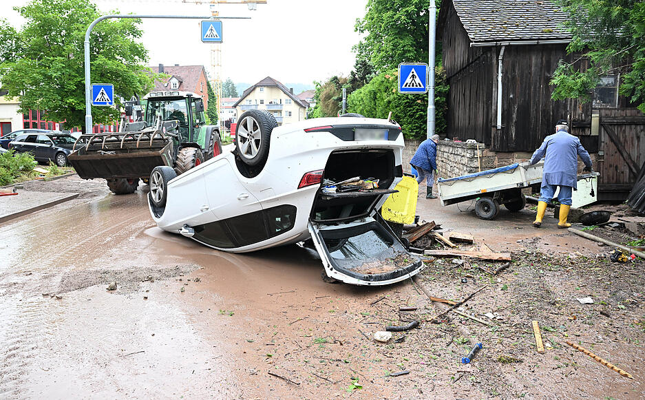 Auf einer Straße in Rudersberg liegt ein durch ein Hochwasser umgestürztes Auto auf dem Dach. Auf einer Straße in Rudersberg liegt ein durch ein Hochwasser umgestürztes Auto auf dem Dach.