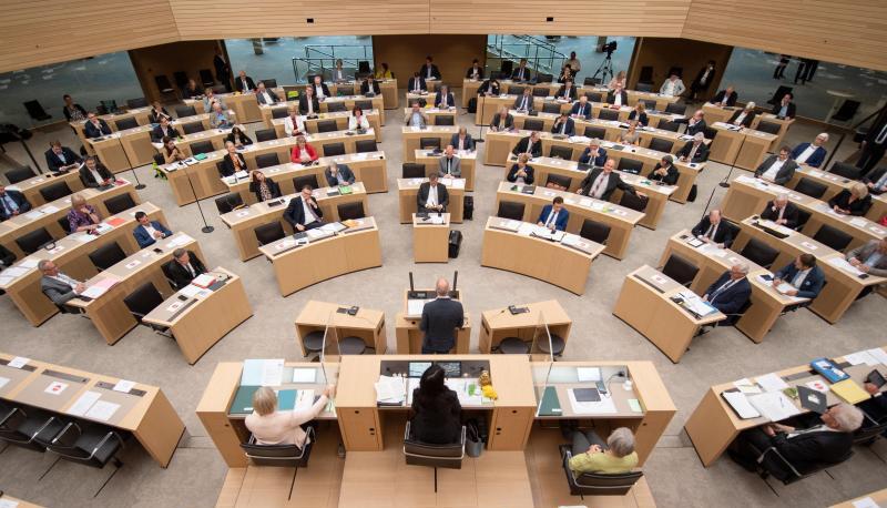 Abgeordnete sitzen bei einer Plenarsitzung im Landtag von Baden-Württemberg mit Abstand zueinander.