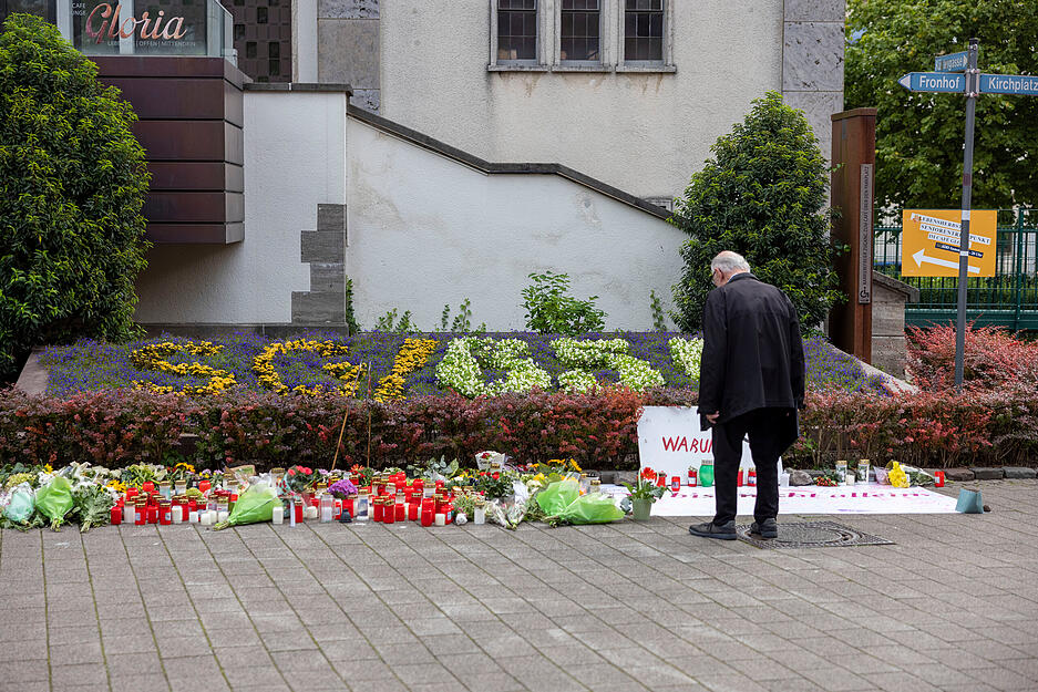 Ein Mann betrachtet Blumen die nach der Messerattacke auf dem Solinger Stadtfest in der Nähe des Tatortes niedergelegt wurden.