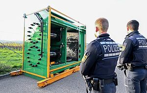 Polizisten stehen vor einer Hydraulikpresse, in der rund 200 Kilogramm Rauschgift sichergestellt wurden.