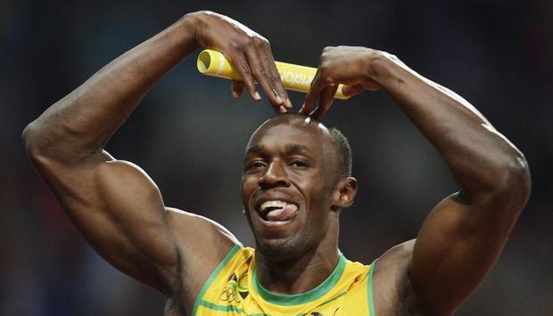 Im Ziel ahmt Usain Bolt die Herz-Geste des Briten Mo Farah nach, der kurz zuvor die 5000 Meter gewann. Foto: Franck Robichon