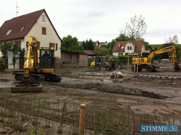 Mit Baggern wird der Schlamm auf der Lauffener Kiesstrasse wegger&auml;umt.