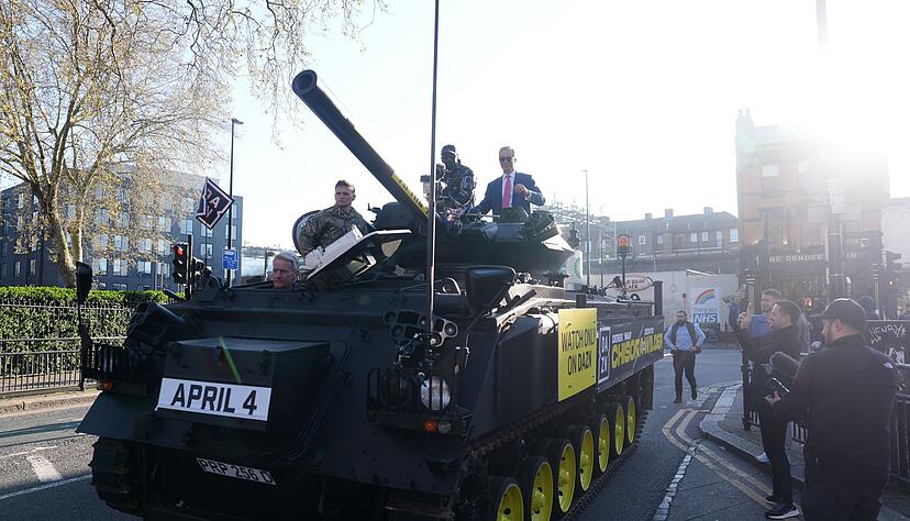Skurriler Auftritt: Boxer Derek Chisora (l) und Politiker Nigel Farage fahren auf einem Panzer durch London.