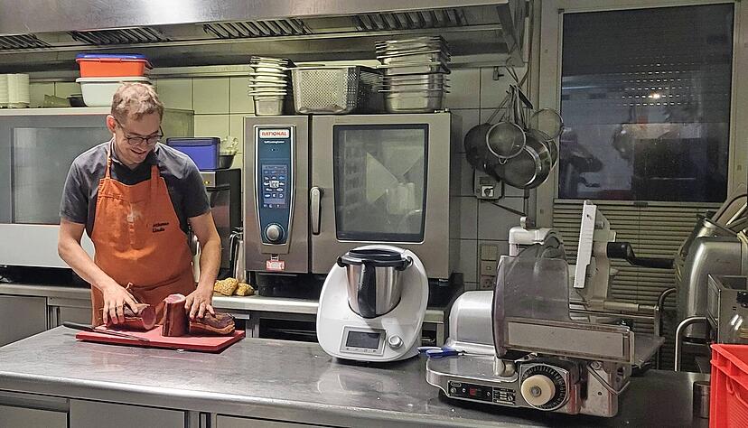Frühmorgens geht es los: Armin Bissinger schneidet den Schinken fürs Frühstücksbuffet. Der junge Küchenchef schwärmt von seinem Job.
Fotos: Sarah Arweiler Frühmorgens geht es los: Armin Bissinger schneidet den Schinken fürs Frühstücksbuffet. Der junge Küchenchef schwärmt von seinem Job.
Fotos: Sarah Arweiler