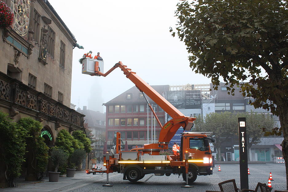 Fr&uuml;hmorgens werden die Blumenst&ouml;cke an der Rathauswand erneuert.