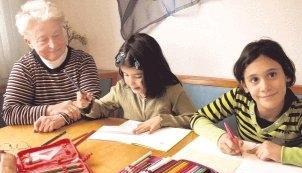 Erika Hartlieb betreut Edanur und Zahide, von links, bei den Hausaufgaben. Sie ist im ehrenamtlichen Team von &bdquo;Durchblick&ldquo; in der Jule Weinsberg.Foto: St&ouml;hr-Michalsky