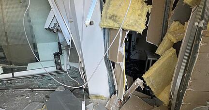 Mitarbeiter der Sparkasse sicherten die zerstörten Fenster mit Pressspanplatten. Mitarbeiter der Sparkasse sicherten die zerstörten Fenster mit Pressspanplatten.