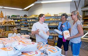 Lena Oettinger ber&auml;t die Kundinnen Olga Maletz und Anna Brester beim Mehlkauf im M&uuml;hlenl&auml;dle. Zunehmend nachgefragt wird Dinkelmehl.