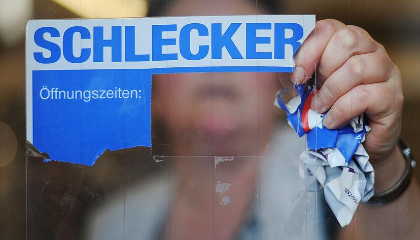 Eine Mitarbeiterin der Drogeriemarktkette Schlecker reißt im März 2012 das Firmenlogo von der Eingangstür einer Filiale. Eine Mitarbeiterin der Drogeriemarktkette Schlecker reißt im März 2012 das Firmenlogo von der Eingangstür einer Filiale.