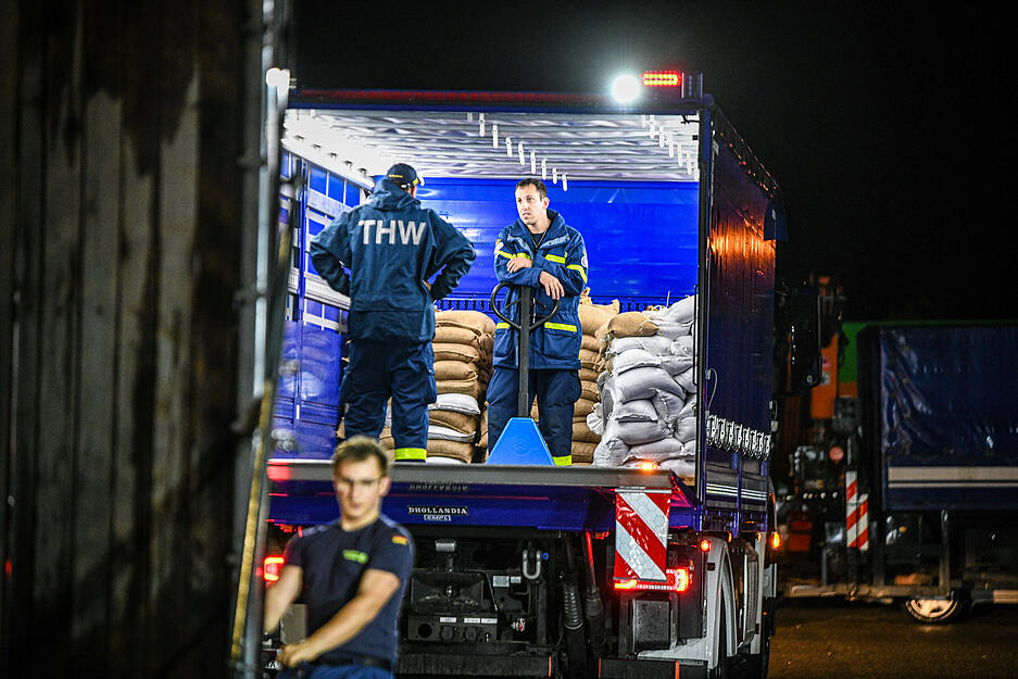 Einsatzkräfte des Technischen Hilfswerks (THW) laden am Logistikzentrum Sandsäcke für Süddeutschland.