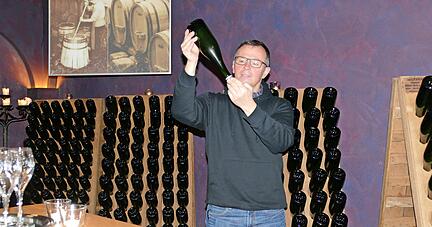 Jürgen Willy begutachtet die Hefe, die sich durch leichtes Bewegen der Flaschen auf den Rüttelpulten am Kronkorken absetzt.   
Foto: Helga El-Kothany