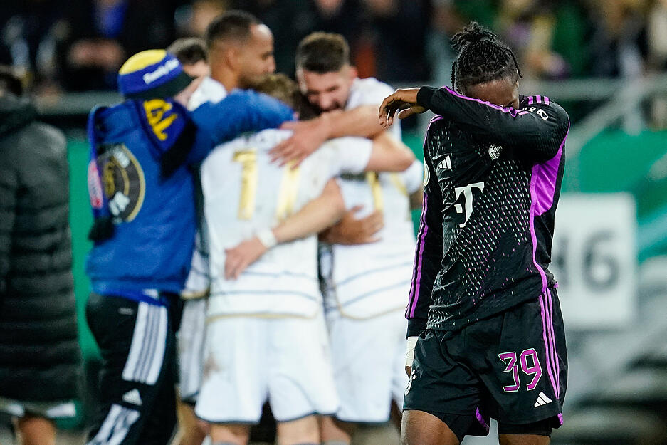 Münchens Mathys Tel (r) geht an feiernden Saarbrücker Spielern vorbei. Münchens Mathys Tel (r) geht an feiernden Saarbrücker Spielern vorbei.
