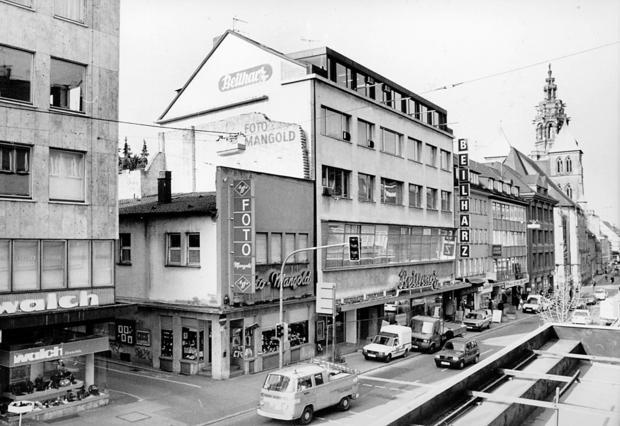 1991: Als Zeitzeuge der Nachkriegszeit gilt die Baulücke Kaiserstraße 50, das Fotogeschäft Mangold. In der Kaiserstraße rollt noch der Autoverkehr.