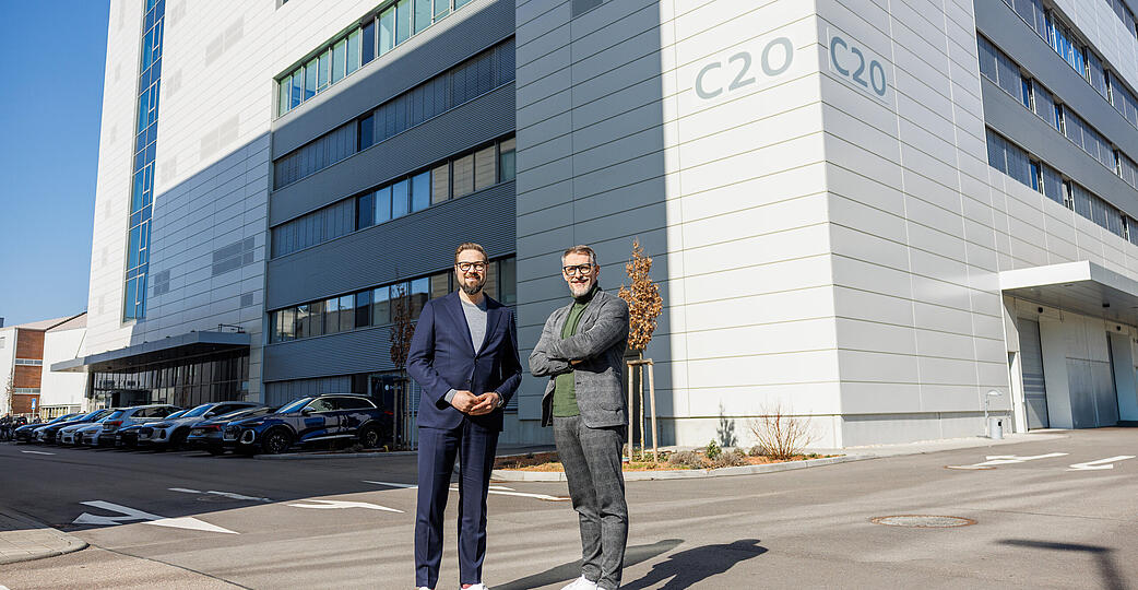 Verantworten bei Audi in Neckarsulm die Verbrenner- und Hochvoltentwicklung: Matthias Honzen (links) und Jens Baumann vor dem Multifunktionsgeb&auml;ude C20.