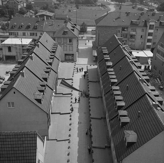 undatierte Aufnahme: Ein Blick vom Hafenmarktturm auf die modern gestaltete Gustav-Binder-Stra&szlig;e. Im Erdgeschoss befinden sich L&auml;den mit weit vorspringenden D&auml;chern. Dar&uuml;ber, einige Meter zur&uuml;ckgesetzt, sind Wohnungen f&uuml;r Familien. In Hintergrund ist der Stadtgarten zu erkennen.