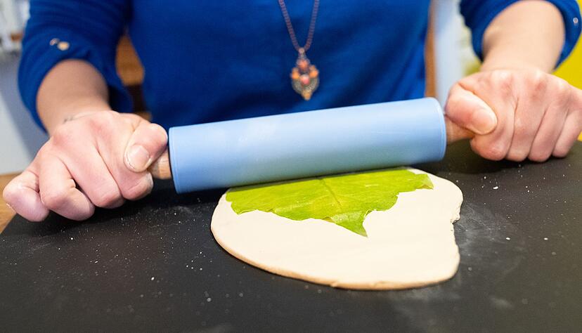 Erst den Ton ausrollen, dann das Blatt darauflegen und langsam mit dem Nudelholz in den Ton drücken.