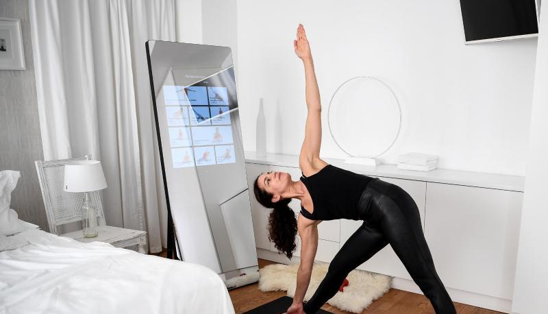 Eine Frau trainiert mit dem interaktiven Spiegel der Firma Vaha. Eine Frau trainiert mit dem interaktiven Spiegel der Firma Vaha.