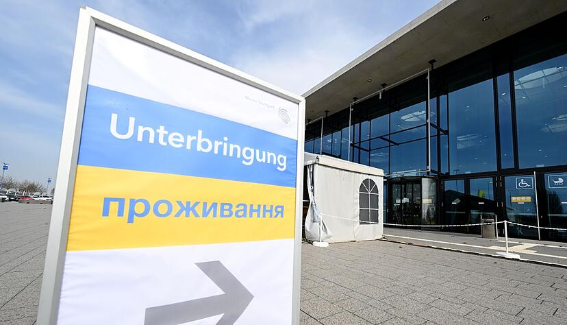 Ein Hinweisschild zeigt den Weg für Flüchtlinge aus der Ukraine in eine Messehalle an der Messe Stuttgart.