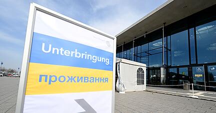Ein Hinweisschild zeigt den Weg für Flüchtlinge aus der Ukraine in eine Messehalle an der Messe Stuttgart.