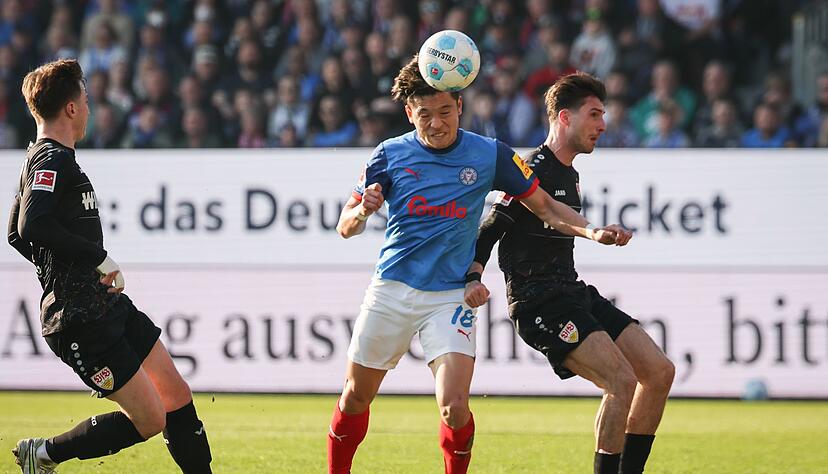 Kiels Shuto Machino (M) beim Kopfball.