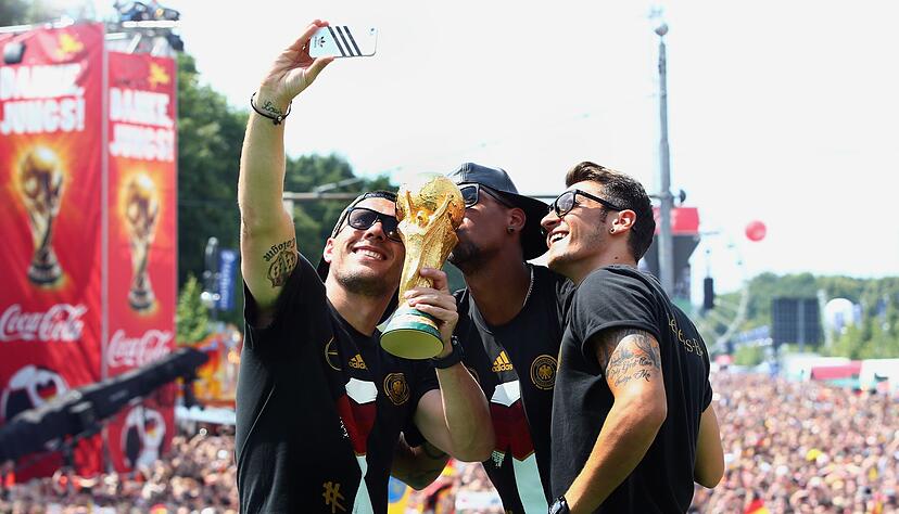 Feierten 2014 den WM-Titel: Mesut &Ouml;zil (r) mit seinen damaligen Teamkollegen Lukas Podolski (l) und Jerome Boateng. (Archivbild)