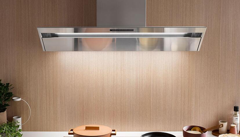 Gl&auml;nzend gel&ouml;st:&nbsp;Hier stellt die prominent mit den anderen Materialen kontrastierende Dunstabzugshaube einen Blickfang dar.