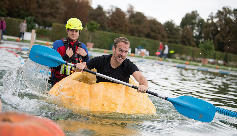 Ein Teilnehmer paddelt während des ersten Tages der Kürbis-Boot-Regatta im Blühenden Barock in Ludwigsburg (Baden-Württemberg) in einem Kürbis-Boot. Foto: dpa