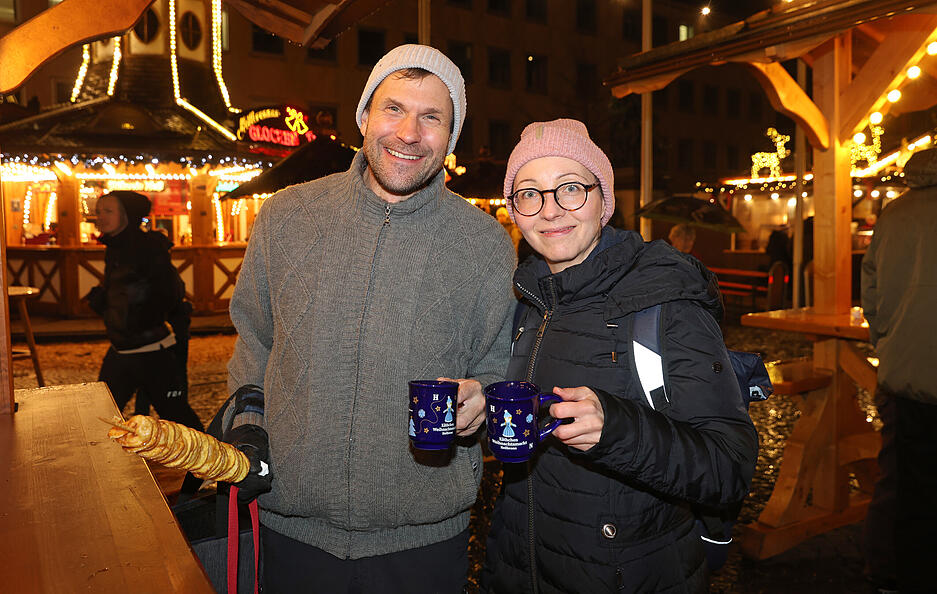 Besucher des Weihnachtsmarktes stoßen mit Heißgetränken auf die Eröffnung an. Besucher des Weihnachtsmarktes stoßen mit Heißgetränken auf die Eröffnung an.
