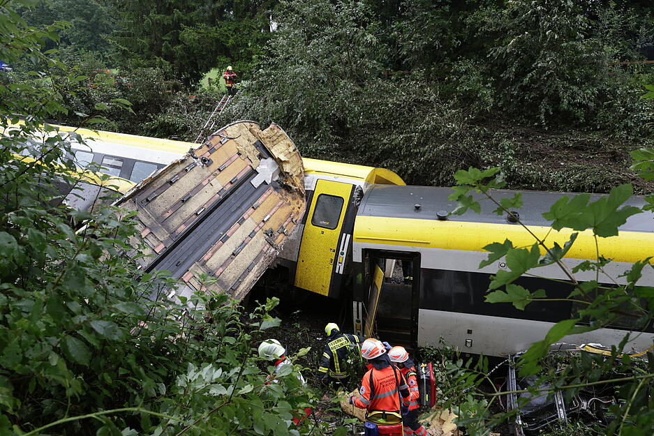 Rettungskräfte suchen in einem entgleisten Zug nach Fahrgästen.