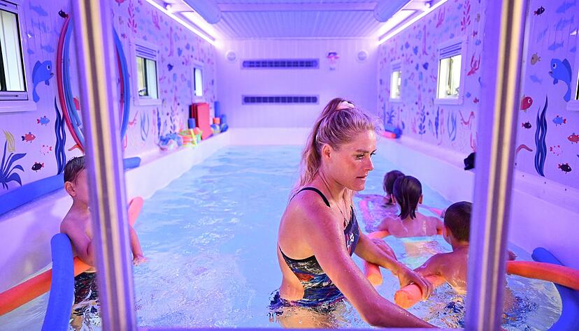 Kinder lernen in einem mobilen Schwimmbecken schwimmen.