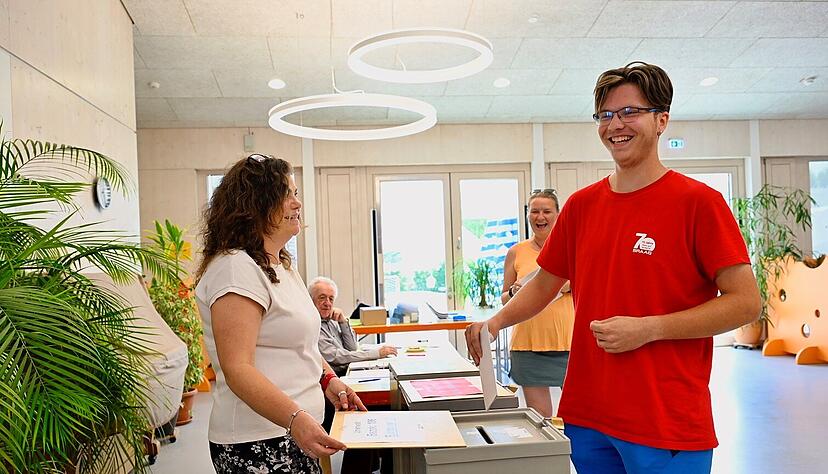 Erstwähler Marcel Gujaca gibt zum ersten Mal Beilstein seine Stimme ab. Wahlhelferin Iris Tobie öffnet für seinen Stimmzettel die Wahlurne.