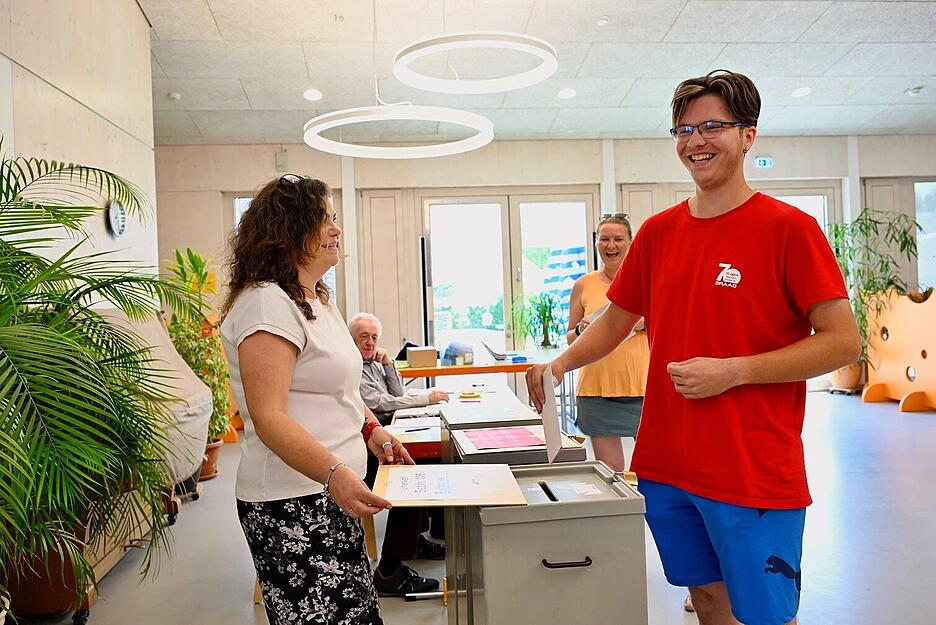 Erstwähler Marcel Gujaca gibt zum ersten Mal Beilstein seine Stimme ab. Wahlhelferin Iris Tobie öffnet für seinen Stimmzettel die Wahlurne.