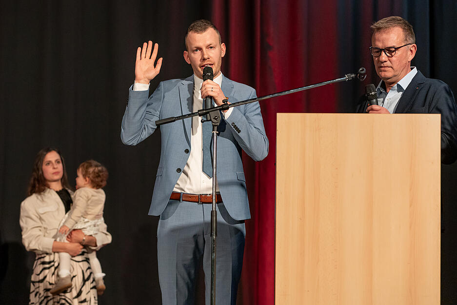 Bürgermeister-Stellvertreter Udo Neuweiler (rechts) nimmt Steffen Braun den Amtseid ab. Im Hintergrund unterstützen Ehefrau Linda und Töchterchen Lou.