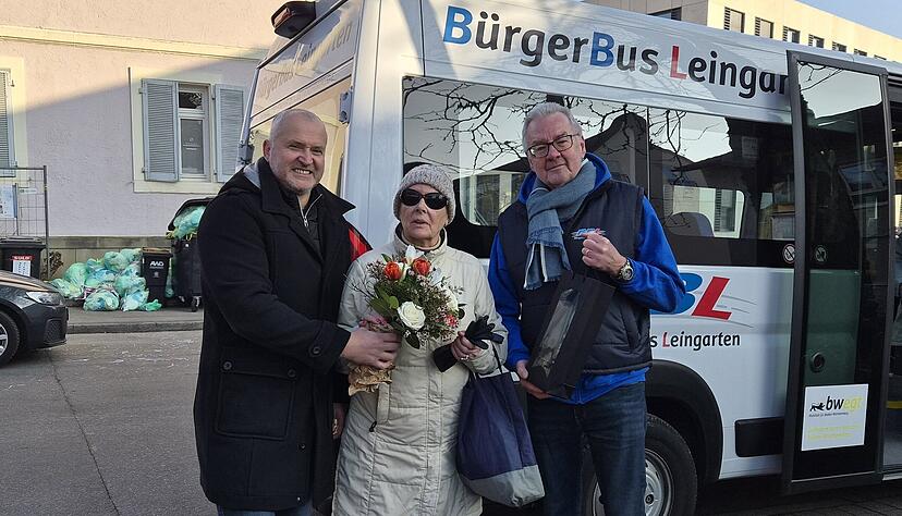 B&uuml;rgermeister Ralf Steinbrenner (links) &uuml;berreicht gemeinsam mit B&uuml;rgerbusfahrer Klaus Werner dem 25.000. Fahrgast, Edelgard Drechsel, ein kleines Dankesch&ouml;n.