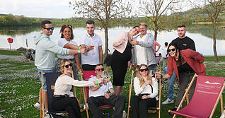Die Besucher genie&szlig;en die Sonne beim Fest &bdquo;Wein am See" am Breitenauer See.