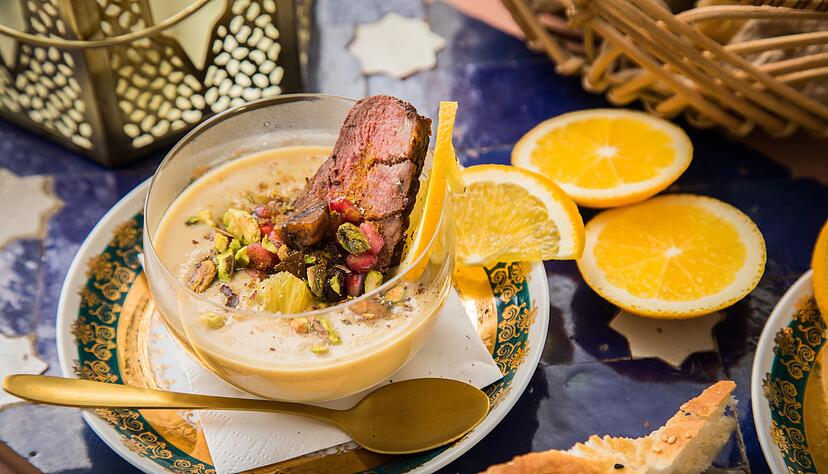Die Maronencremesuppe mit gebratener Entenbrust wird mit gegens&auml;tzlichen Aromen getoppt: Pistazien sorgen f&uuml;r S&uuml;&szlig;e, die Gew&uuml;rzmischung Ras El Hanout f&uuml;r Sch&auml;rfe und die Orangenscheiben f&uuml;r fruchtige Aromen.