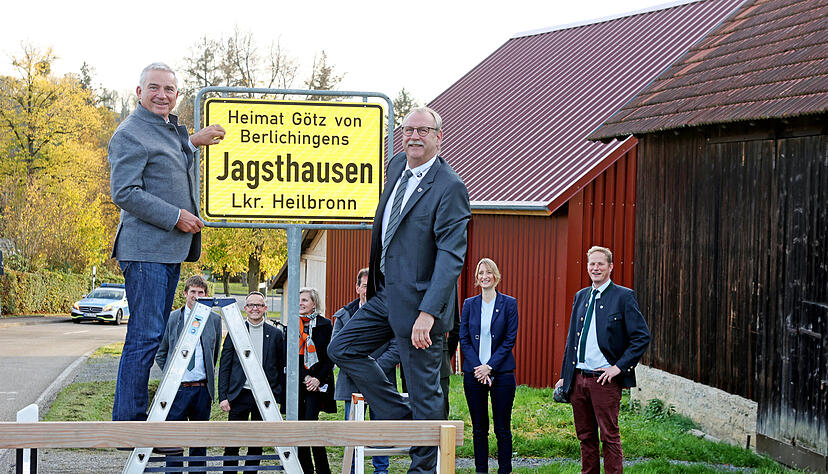 Thomas Stobl und Bürgermsiter Roland Halter bringen das neue Ortsschild in Jagsthausen an mit dem Zusatz "Heimat Götz von Berlichingen"