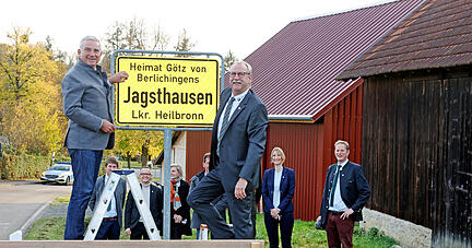 Thomas Stobl und Bürgermsiter Roland Halter bringen das neue Ortsschild in Jagsthausen an mit dem Zusatz "Heimat Götz von Berlichingen"