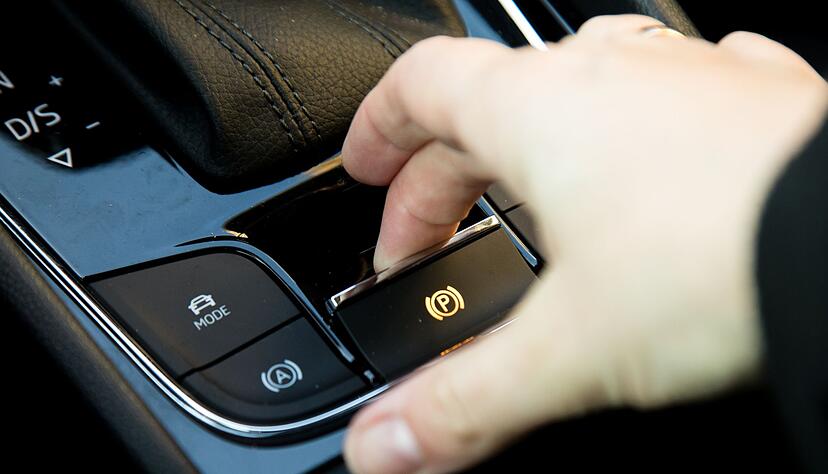 Weder langer Handbremshebel noch Pedal f&uuml;r den Fu&szlig; wie fr&uuml;her bei einigen Modellen: Bei modernen Autos gibt es oft nur einen kleines Hebelchen f&uuml;r eine elektrische Feststellbremse.