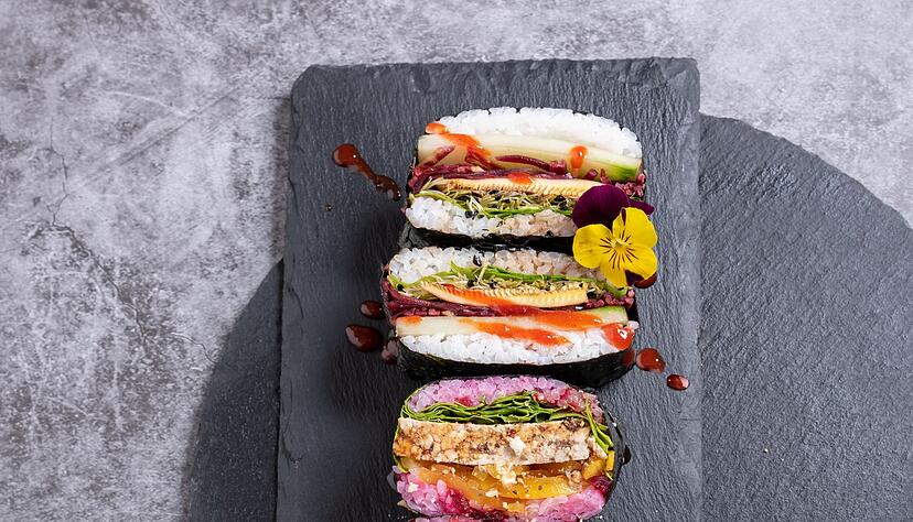 Wer sich f&uuml;r die Vorbereitung etwas mehr Zeit nimmt, kann Sushi-Sandwiches mitbringen - ein hier noch mit essbaren Bl&uuml;ten verzierter Hingucker.