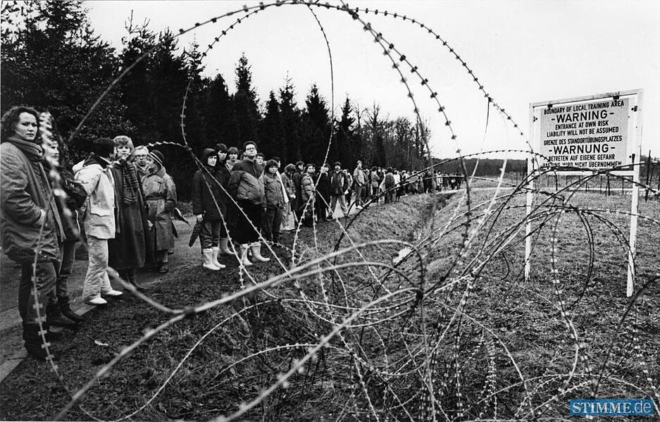 Vor dem Stacheldraht des Raketenstützpunktes verteilen sich Teilnehmer des Schweigemarsches rund um die Waldheide am 2. Februar 1985.
