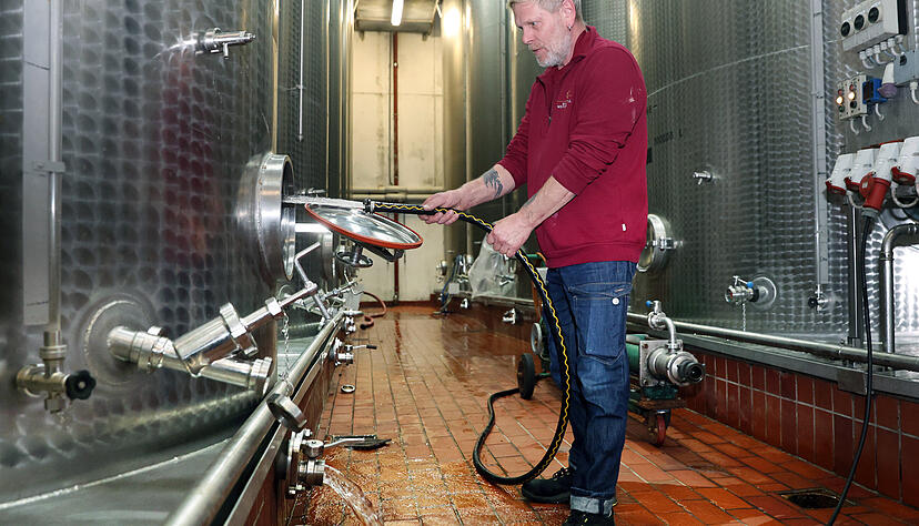 Uwe Schneider reinigt einen der großen Tanks, nachdem der Wein umgepumpt wurde. Etliche Tanks sind in diesem Jahr leer oder nur teilweise gefüllt.